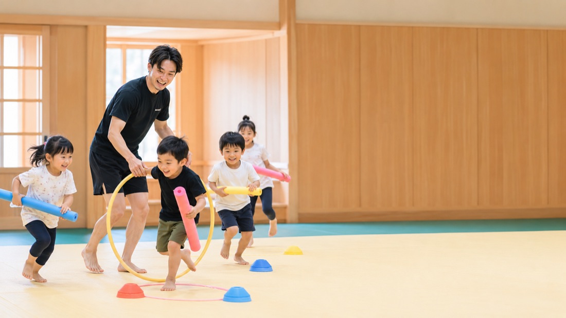 フープをくぐり、棒を持って走るこどもたち